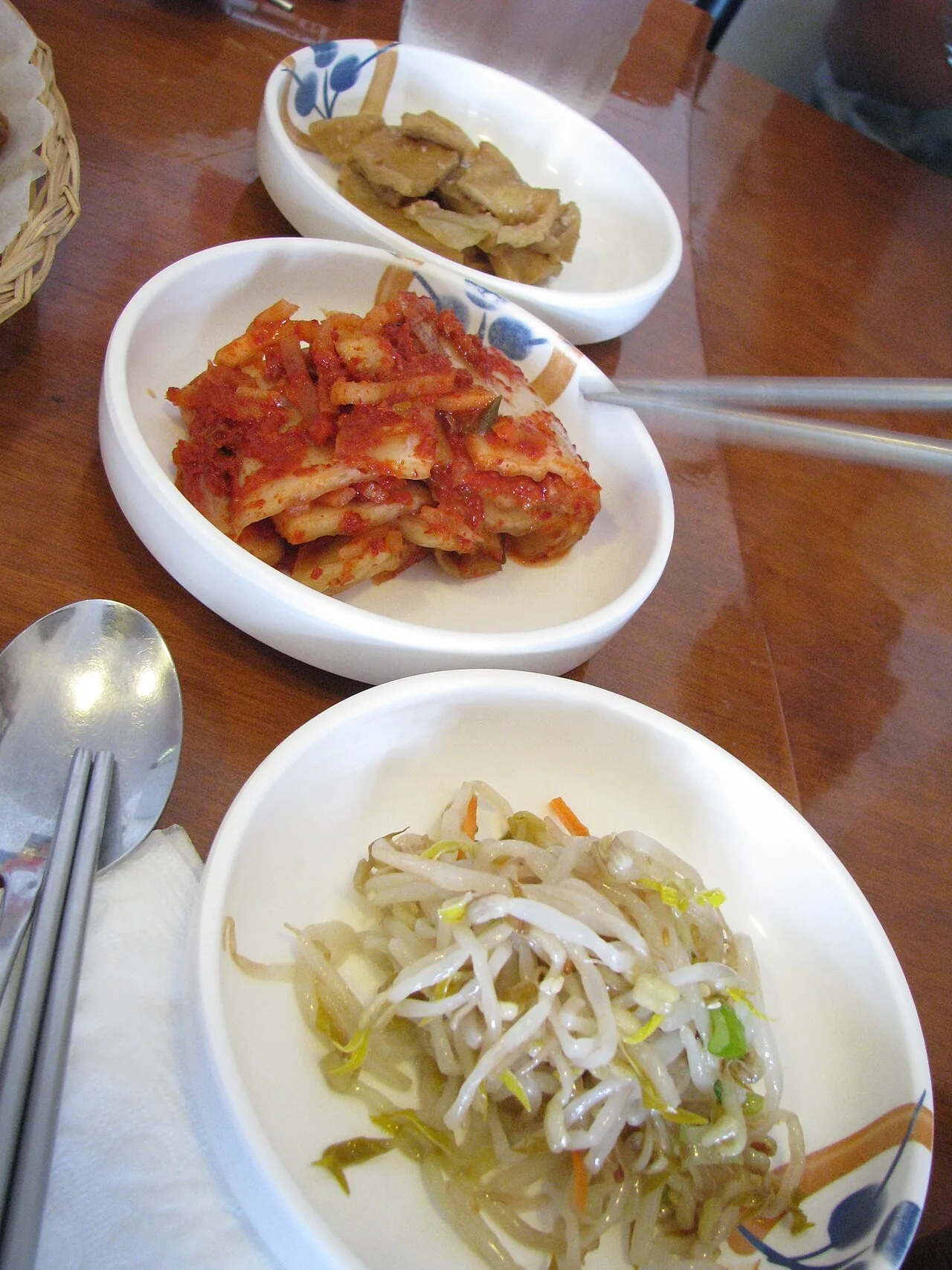 숙주나물, 김치, 어묵조림이 담긴 반찬 접시 세 개.